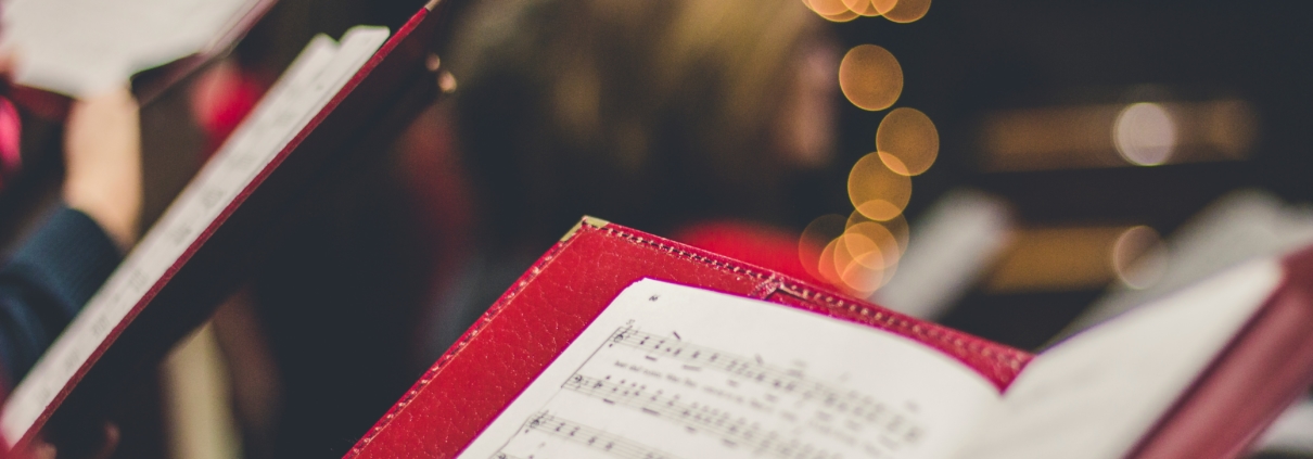 Photo of a sheet of music being held up by a member of a chorus